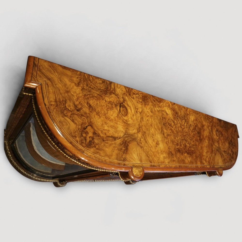 A Victorian burr walnut credenza featuring a central marquetry inlaid door flanked by two curved glazed display side cabinets with gilt mounts. View XIII