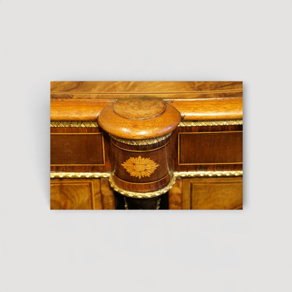 A Victorian burr walnut credenza featuring a central marquetry inlaid door flanked by two curved glazed display side cabinets with gilt mounts. View XIV