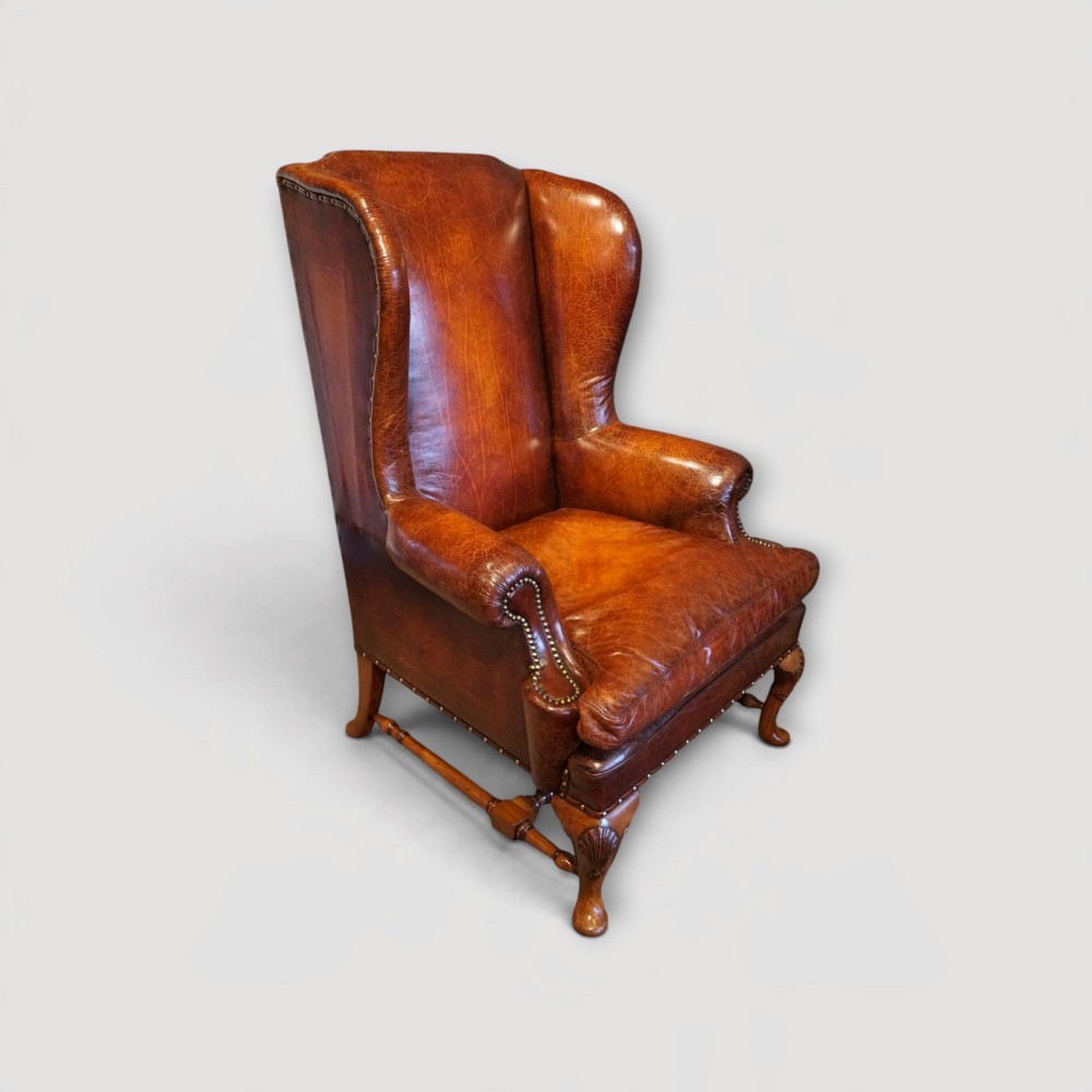 A pair of brown leather Queen Anne style wingback armchairs featuring deep seat cushions, brass stud detailing, and carved walnut cabriole legs. View II
