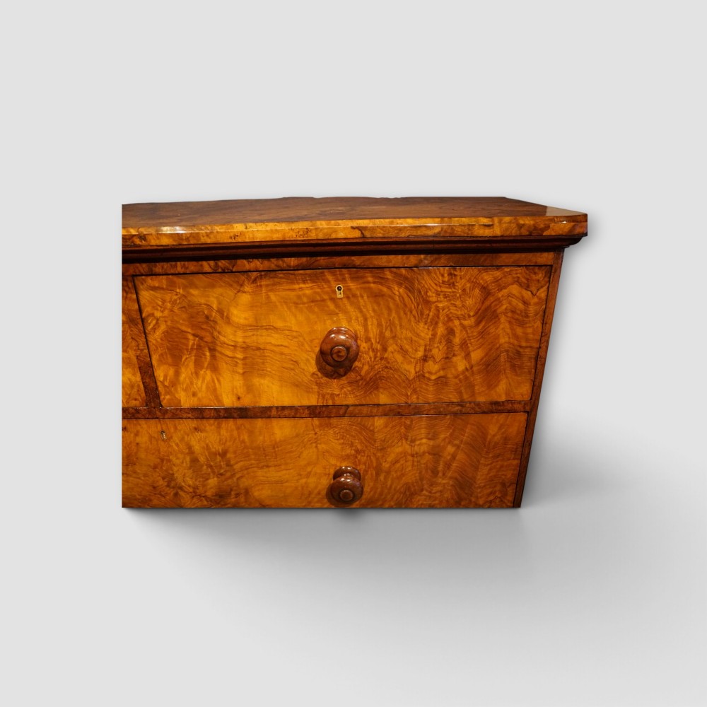 A Victorian burr walnut chest of drawers featuring two short drawers over three long drawers with turned walnut knobs and a plinth base. View VIII