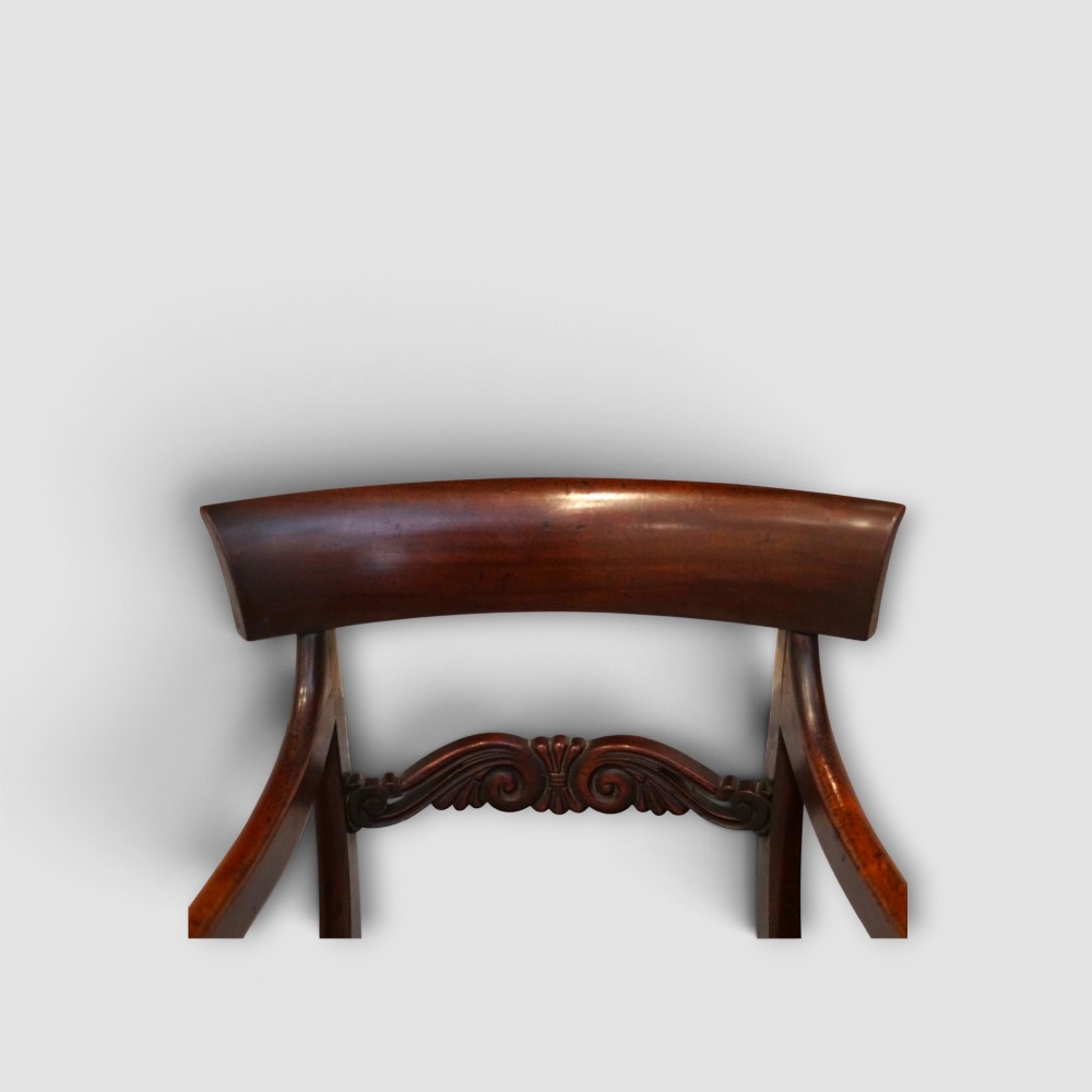 A set of eight William IV dark mahogany dining chairs comprising six side chairs and two carvers with turned front legs and light neutral upholstered seats. View II