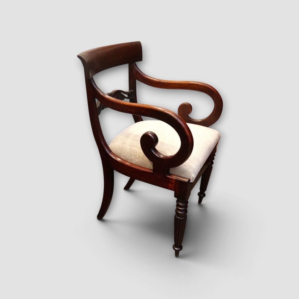 A set of eight William IV dark mahogany dining chairs comprising six side chairs and two carvers with turned front legs and light neutral upholstered seats. View III