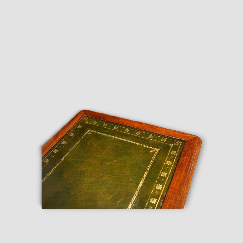 An early Victorian mahogany writing table featuring a green leather inset top with gilt tooling, two frieze drawers, a turned stretcher, and end supports. View III