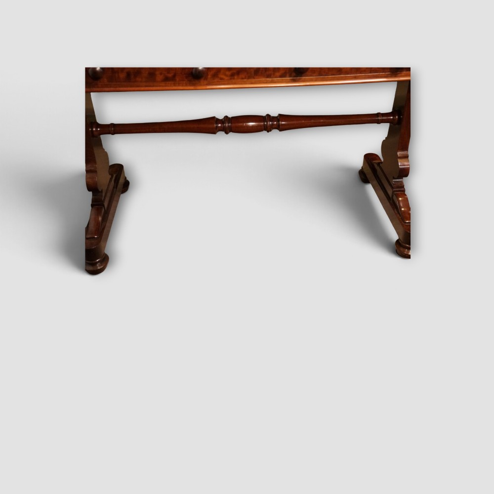 An early Victorian mahogany writing table featuring a green leather inset top with gilt tooling, two frieze drawers, a turned stretcher, and end supports. View XII