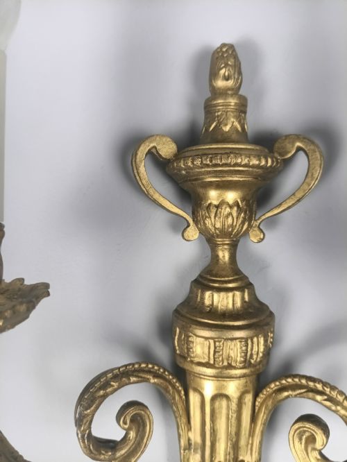 fig 5. Set of three French gilded brass wall sconces featuring twin scrolling arms and urn-shaped tapered backplates.
