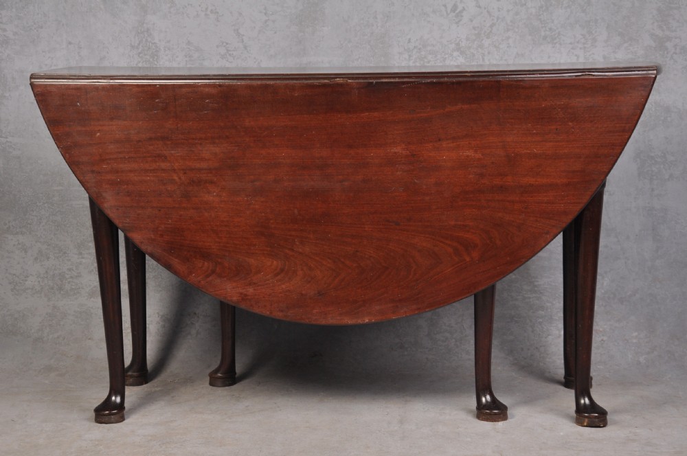 An 18th-century mahogany gateleg table featuring a drop-leaf top, hinged rounded leaves, and slender cabriole legs terminating in pad feet.