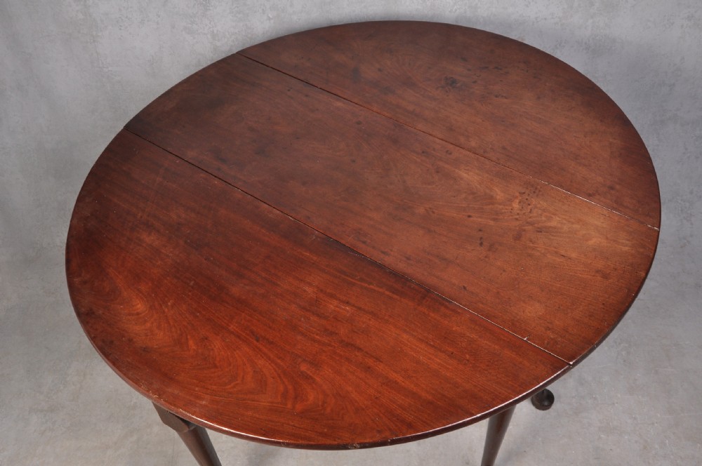 An 18th-century mahogany gateleg table featuring a drop-leaf top, hinged rounded leaves, and slender cabriole legs terminating in pad feet. View VIII