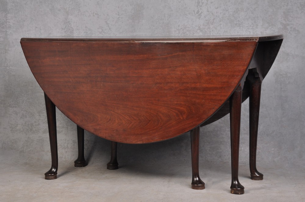 An 18th-century mahogany gateleg table featuring a drop-leaf top, hinged rounded leaves, and slender cabriole legs terminating in pad feet. View IX