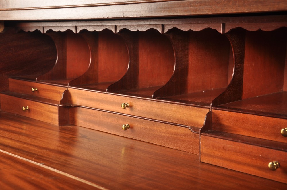 An 18th-century Georgian flame mahogany tallboy featuring a carved fretwork cornice, brass swan-neck handles, and ogee bracket feet. View IV