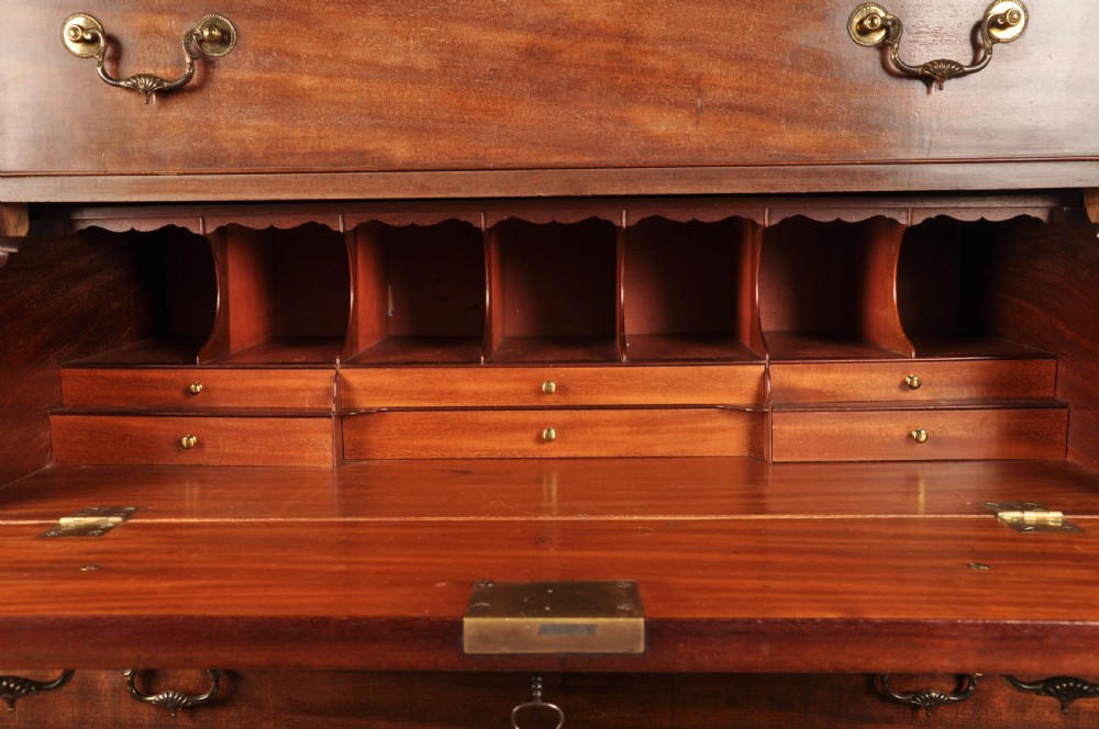 An 18th-century Georgian flame mahogany tallboy featuring a carved fretwork cornice, brass swan-neck handles, and ogee bracket feet. View V