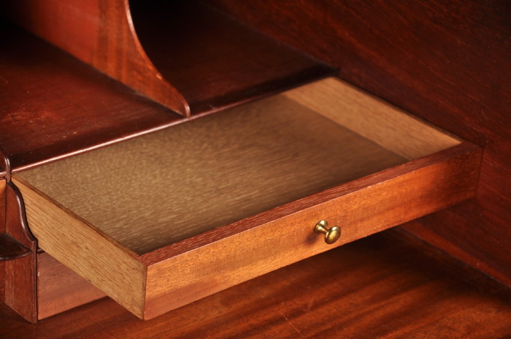 An 18th-century Georgian flame mahogany tallboy featuring a carved fretwork cornice, brass swan-neck handles, and ogee bracket feet. View VI