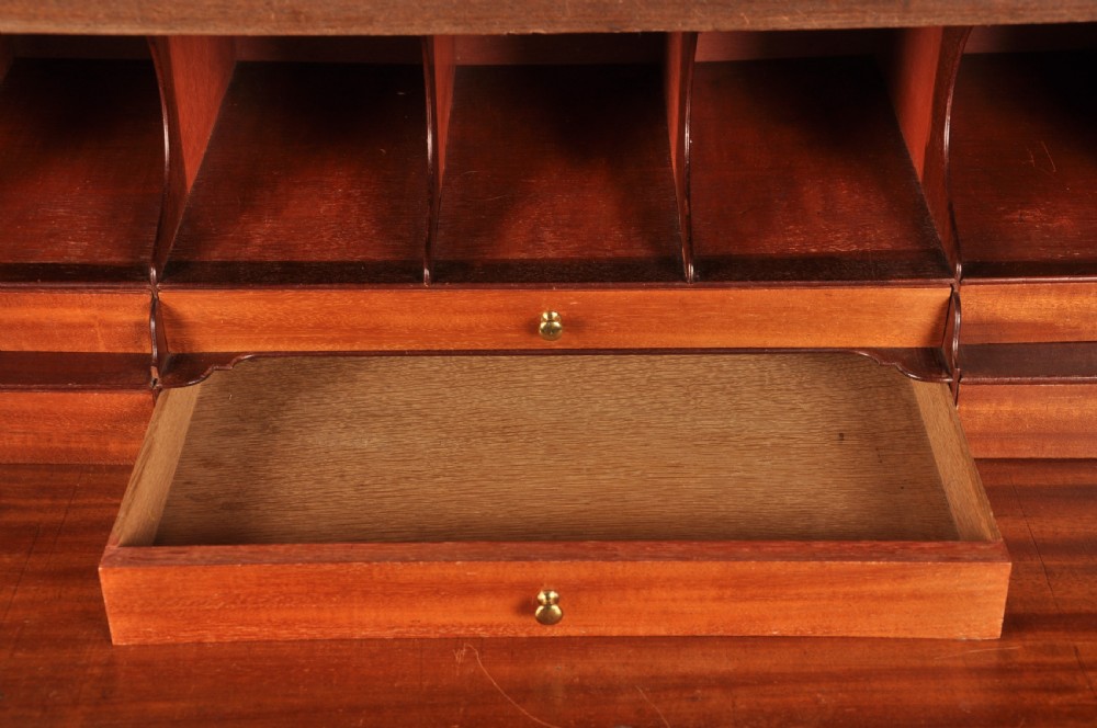 An 18th-century Georgian flame mahogany tallboy featuring a carved fretwork cornice, brass swan-neck handles, and ogee bracket feet. View VII