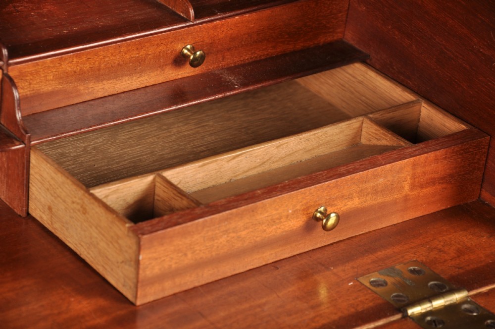 An 18th-century Georgian flame mahogany tallboy featuring a carved fretwork cornice, brass swan-neck handles, and ogee bracket feet. View IX