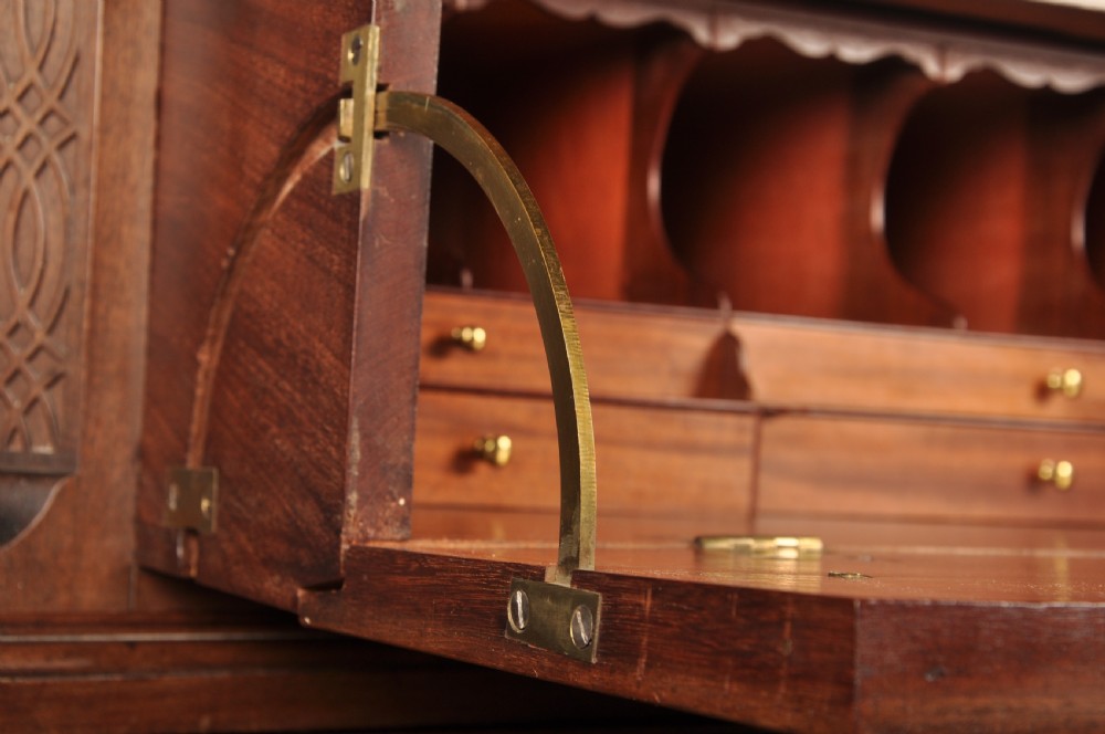 An 18th-century Georgian flame mahogany tallboy featuring a carved fretwork cornice, brass swan-neck handles, and ogee bracket feet. View XII