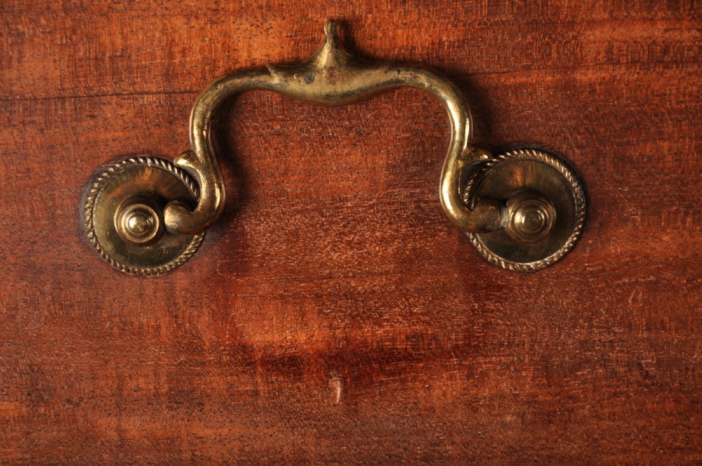 An 18th-century Georgian flame mahogany tallboy featuring a carved fretwork cornice, brass swan-neck handles, and ogee bracket feet. View XIV