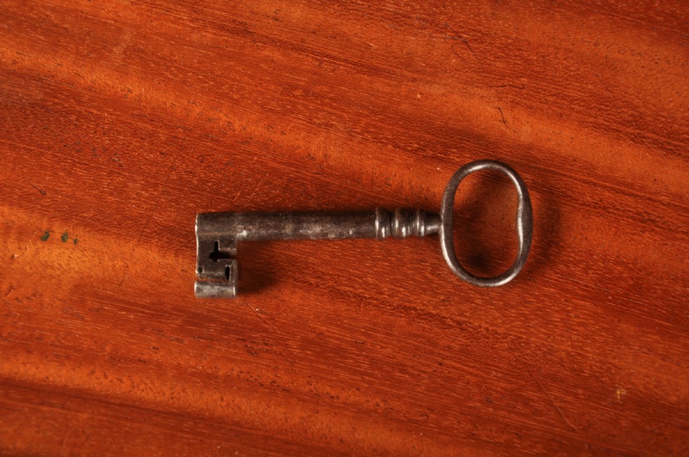 An 18th-century Georgian flame mahogany tallboy featuring a carved fretwork cornice, brass swan-neck handles, and ogee bracket feet. View XV