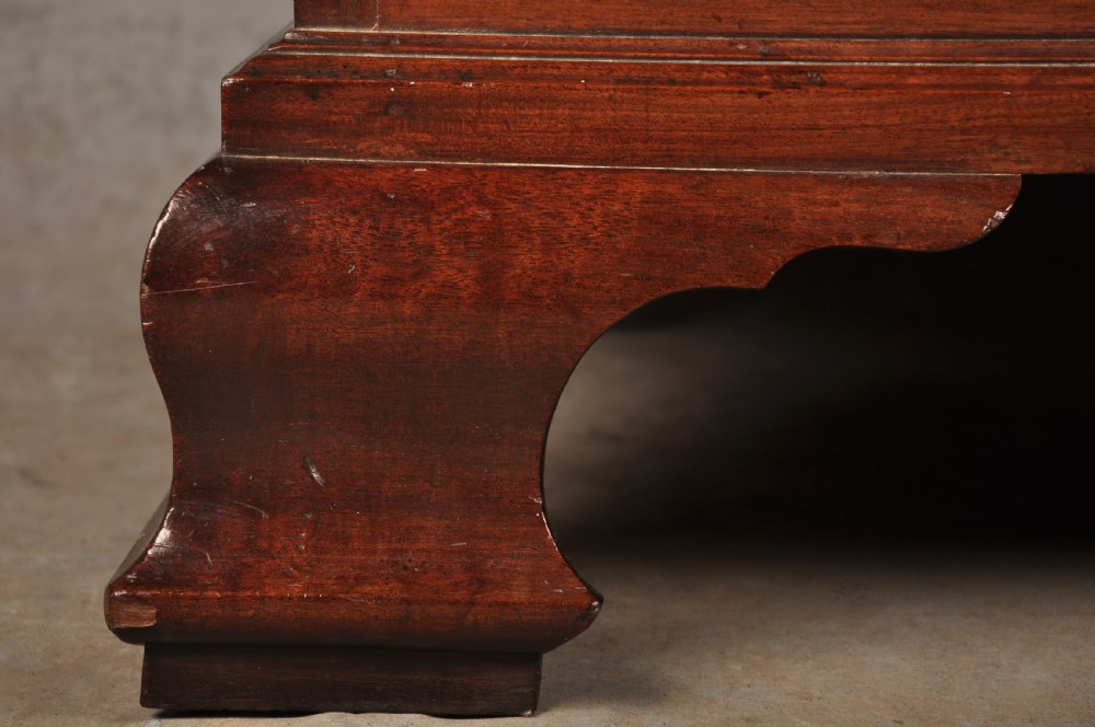 An 18th-century Georgian flame mahogany tallboy featuring a carved fretwork cornice, brass swan-neck handles, and ogee bracket feet. View XVI