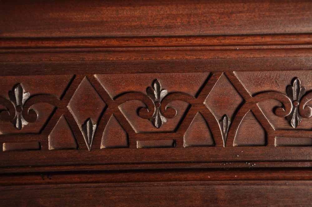 An 18th-century Georgian flame mahogany tallboy featuring a carved fretwork cornice, brass swan-neck handles, and ogee bracket feet. View XVII