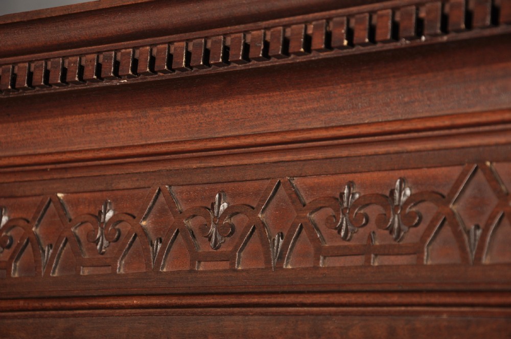 An 18th-century Georgian flame mahogany tallboy featuring a carved fretwork cornice, brass swan-neck handles, and ogee bracket feet. View XVIII