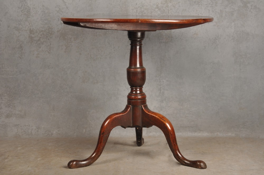 An 18th-century cherrywood tripod table featuring a circular top, turned baluster pedestal, and three splayed cabriole legs. View II