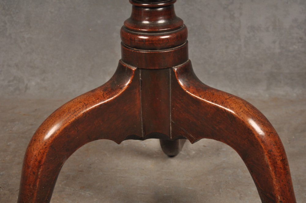 An 18th-century cherrywood tripod table featuring a circular top, turned baluster pedestal, and three splayed cabriole legs. View III