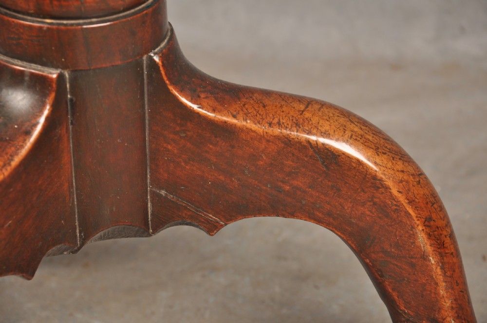 An 18th-century cherrywood tripod table featuring a circular top, turned baluster pedestal, and three splayed cabriole legs. View VI