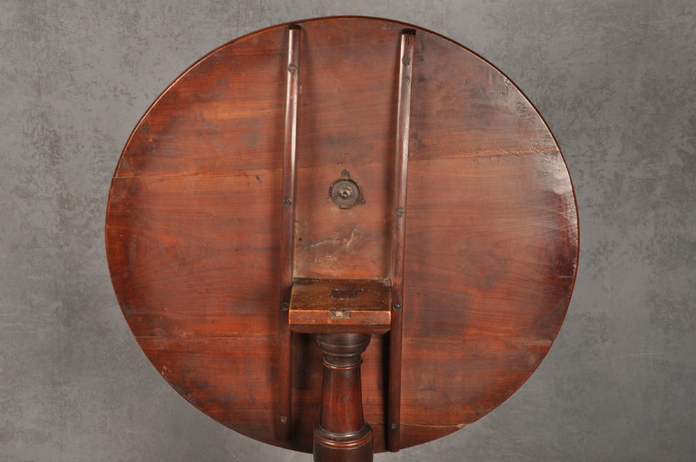 An 18th-century cherrywood tripod table featuring a circular top, turned baluster pedestal, and three splayed cabriole legs. View VII