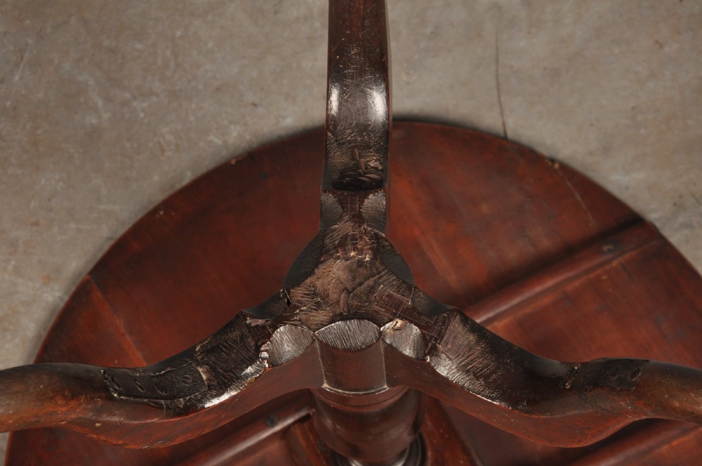 An 18th-century cherrywood tripod table featuring a circular top, turned baluster pedestal, and three splayed cabriole legs. View X