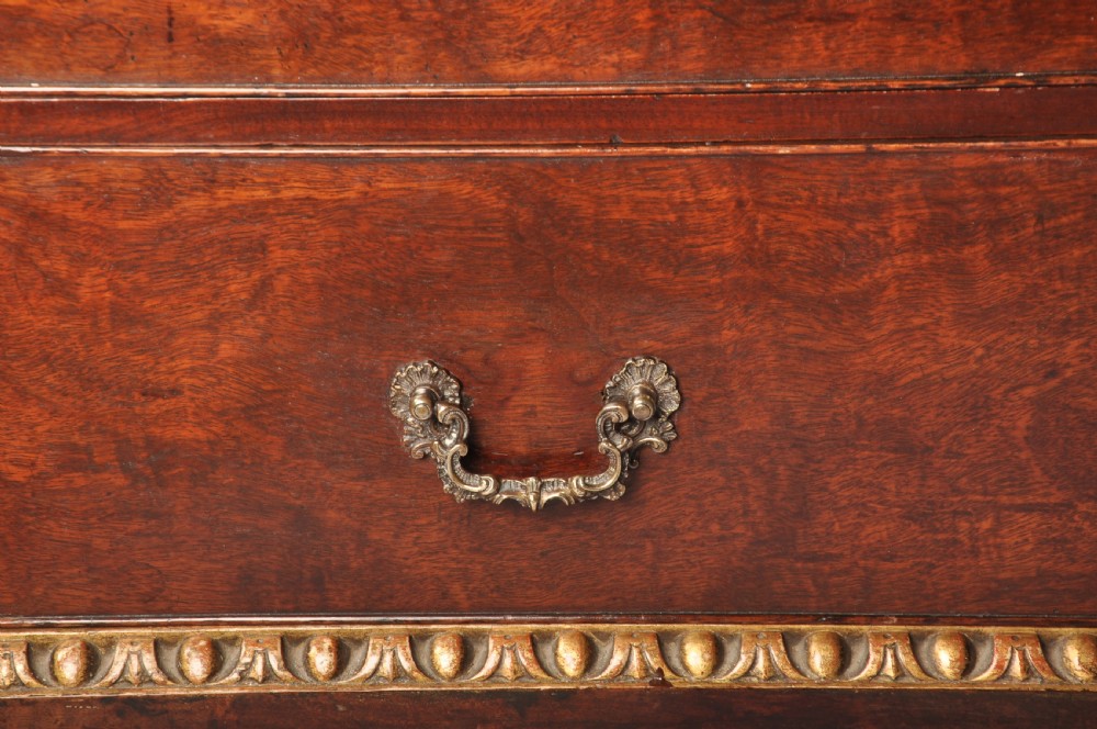 An 18th-century mahogany secretaire cabinet featuring twin upper doors with shaped gilded mouldings above an open fall-front desk with pigeonholes and three drawers on bracket feet. View XV