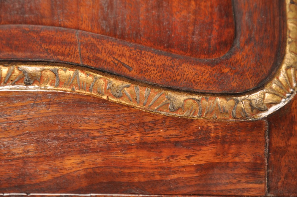 An 18th-century mahogany secretaire cabinet featuring twin upper doors with shaped gilded mouldings above an open fall-front desk with pigeonholes and three drawers on bracket feet. View XVI