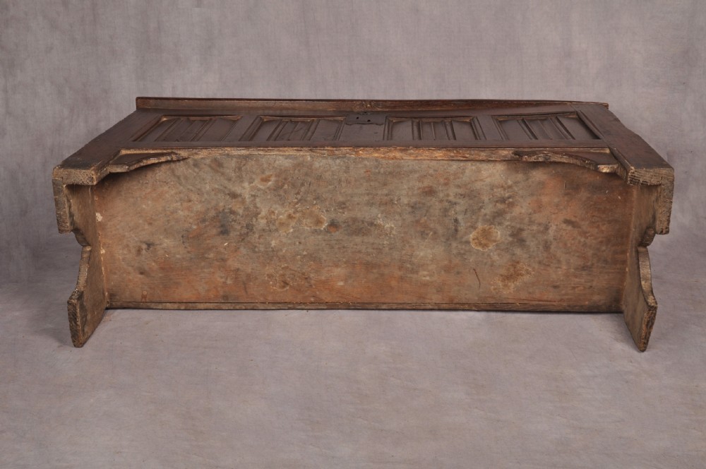 A Tudor era dark oak coffer featuring four carved linenfold panels and an iron lockplate on the front facade. View XII