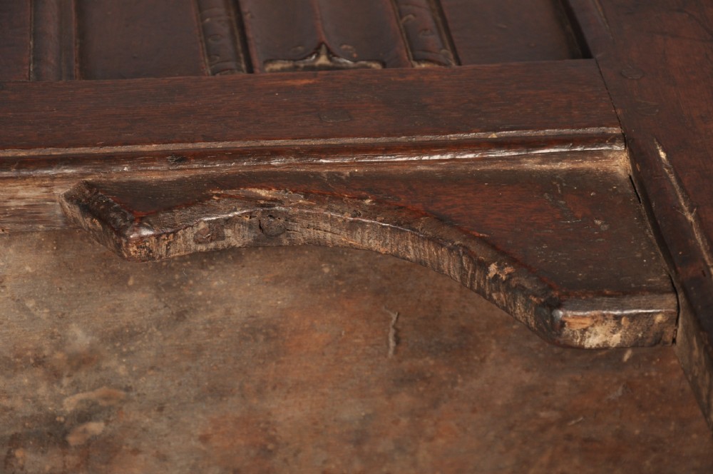 A Tudor era dark oak coffer featuring four carved linenfold panels and an iron lockplate on the front facade. View XIII