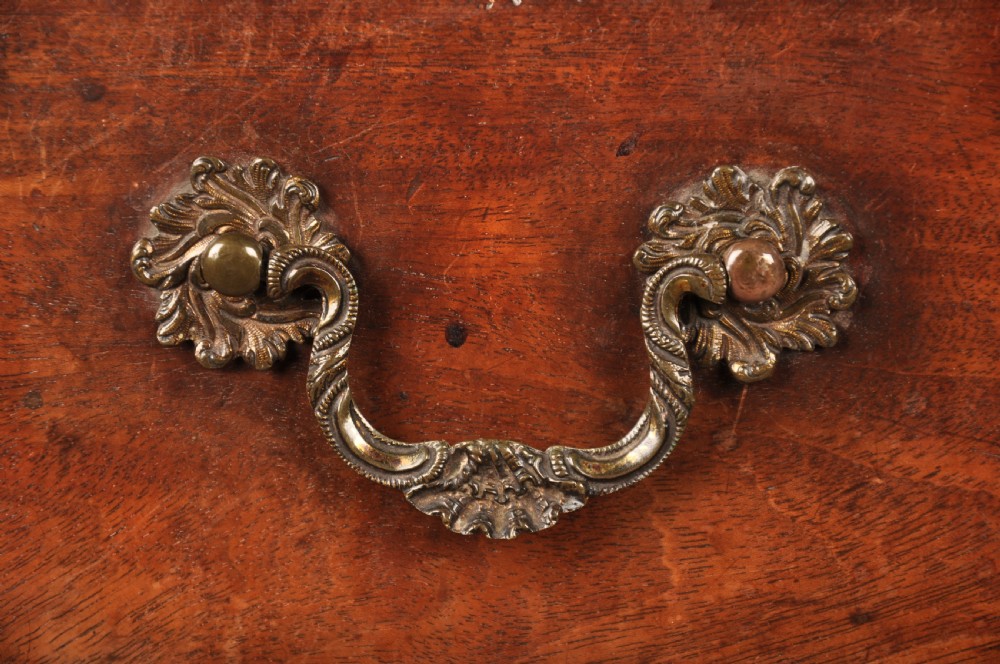 An 18th-century mahogany chest of drawers featuring two short over three long graduated drawers, carved blind fretwork stiles, brass swan-neck handles, and ogee bracket feet. View II