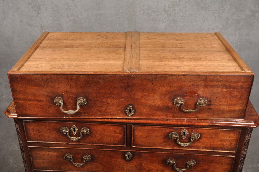An 18th-century mahogany chest of drawers featuring two short over three long graduated drawers, carved blind fretwork stiles, brass swan-neck handles, and ogee bracket feet. View IX