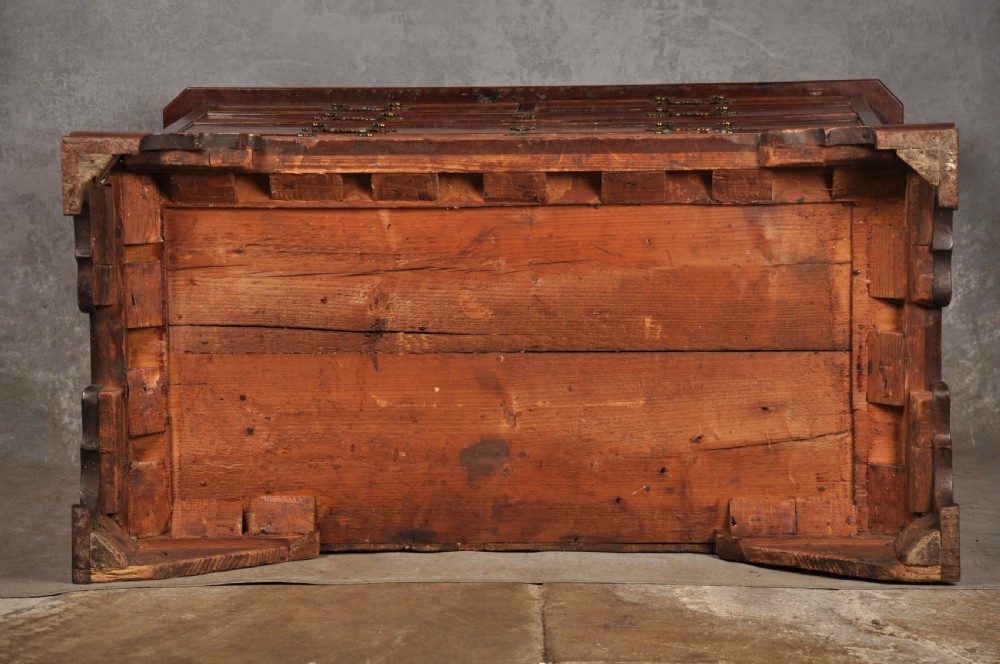An 18th-century mahogany chest of drawers featuring two short over three long graduated drawers, carved blind fretwork stiles, brass swan-neck handles, and ogee bracket feet. View XVI