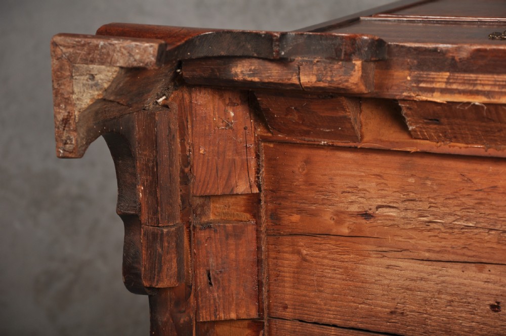 An 18th-century mahogany chest of drawers featuring two short over three long graduated drawers, carved blind fretwork stiles, brass swan-neck handles, and ogee bracket feet. View XVII
