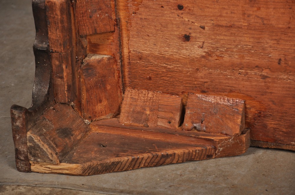 An 18th-century mahogany chest of drawers featuring two short over three long graduated drawers, carved blind fretwork stiles, brass swan-neck handles, and ogee bracket feet. View XVIII