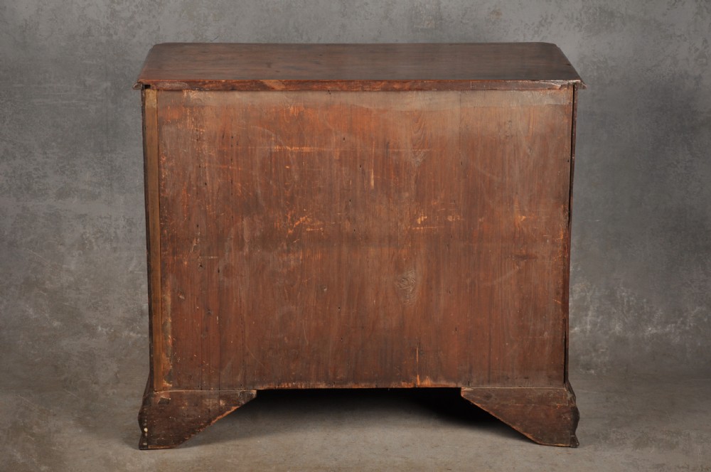 An 18th-century mahogany chest of drawers featuring two short over three long graduated drawers, carved blind fretwork stiles, brass swan-neck handles, and ogee bracket feet. View XIX