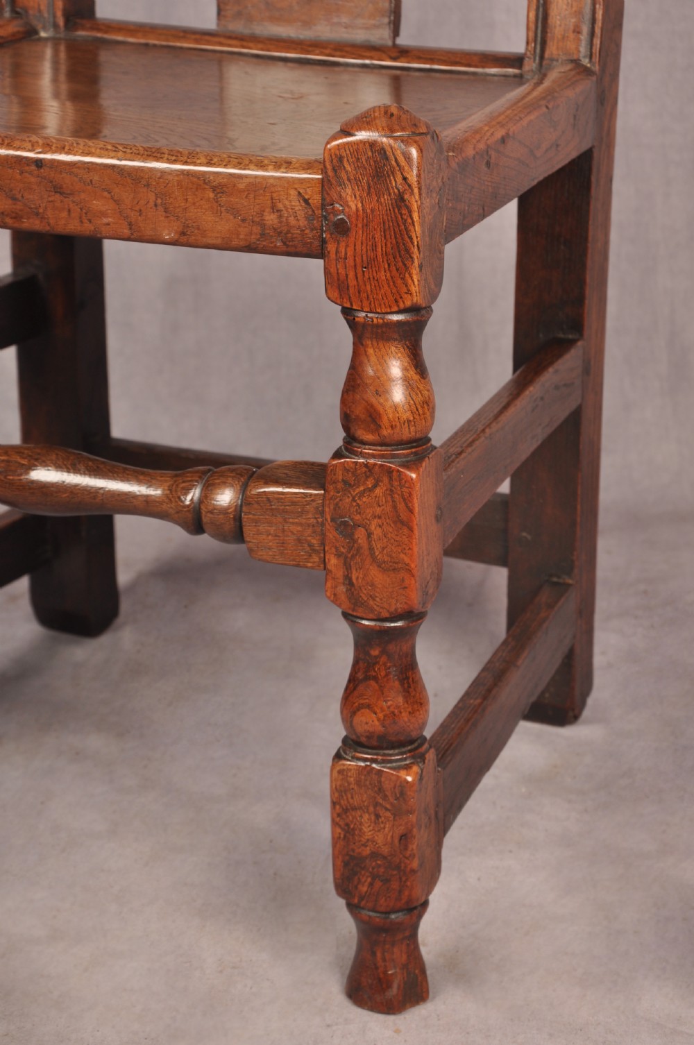 A set of four antique Queen Anne oak and elm side chairs featuring contoured vase backsplats, solid wooden seats, and turned front legs with stretchers. View VI