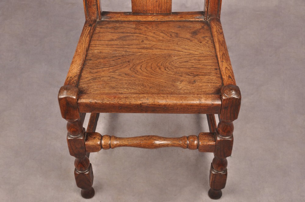 A set of four antique Queen Anne oak and elm side chairs featuring contoured vase backsplats, solid wooden seats, and turned front legs with stretchers. View VII