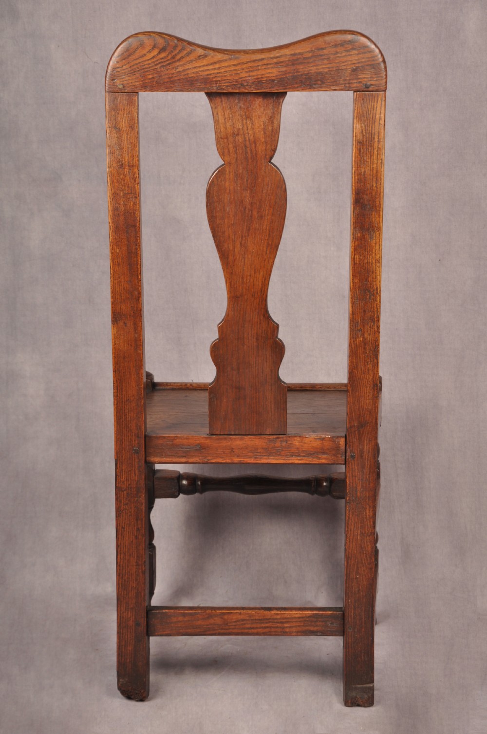 A set of four antique Queen Anne oak and elm side chairs featuring contoured vase backsplats, solid wooden seats, and turned front legs with stretchers. View IX