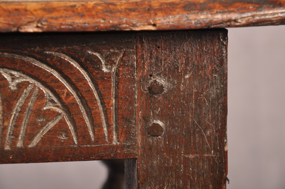 A dark oak joint stool featuring a rectangular moulded top above a carved frieze, supported by turned legs joined by low stretchers. View VIII