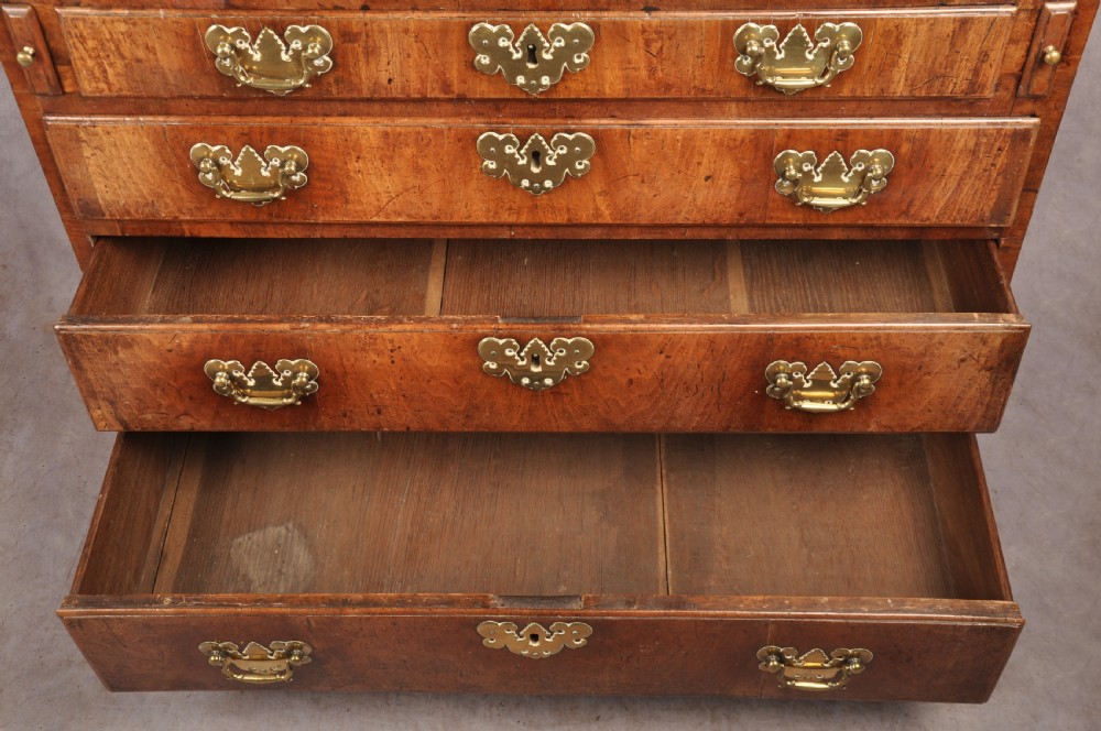 An early eighteenth-century walnut bureau with a sloping fall front, four drawers, decorative brass handles, and bracket feet. View III