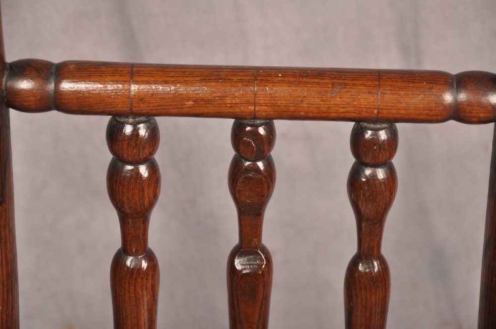 A near pair of dark 17th-century turned ash chairs with spindle backrests, turned stretchers, panel seats, and top finials. View V
