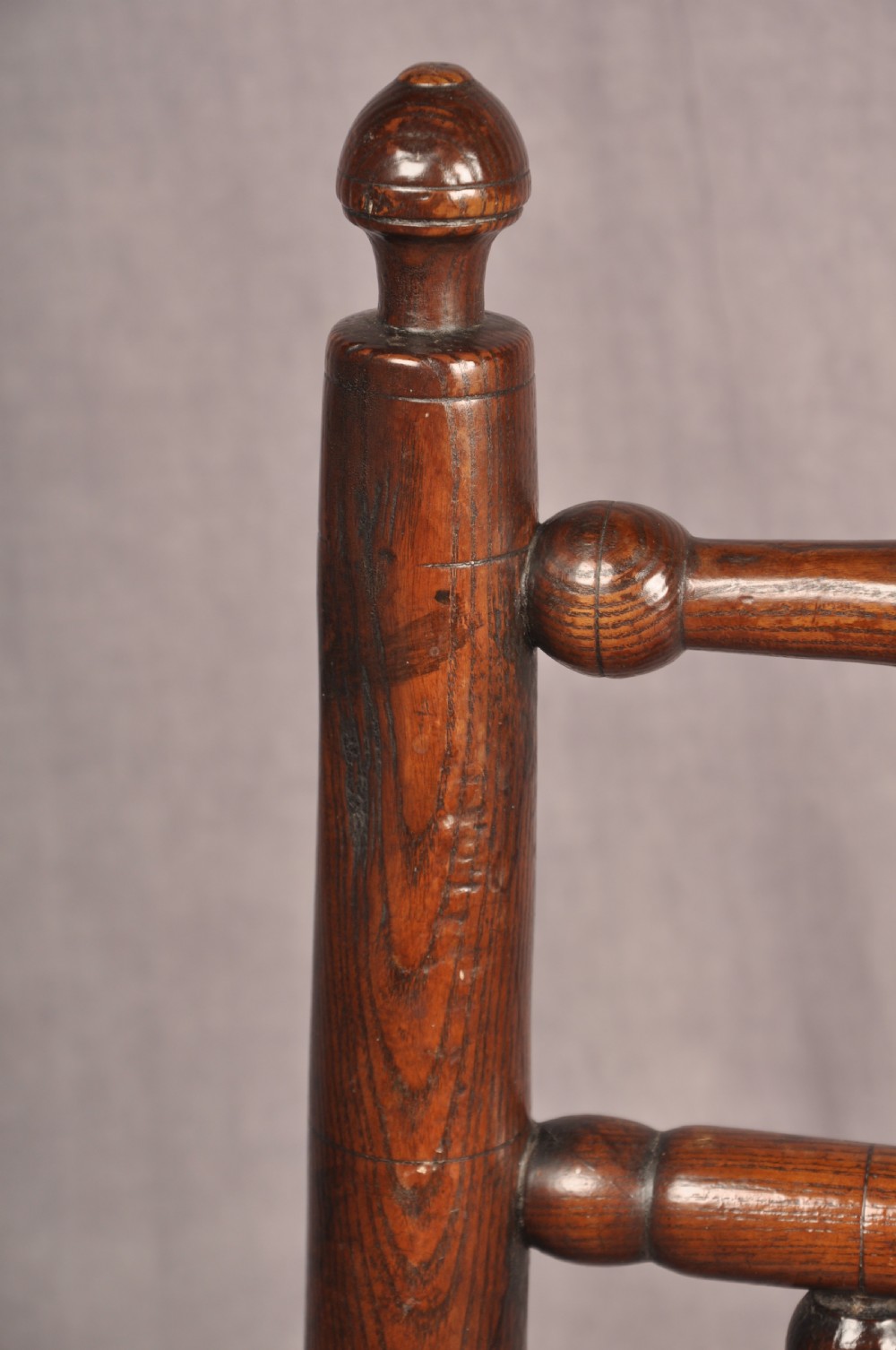 A near pair of dark 17th-century turned ash chairs with spindle backrests, turned stretchers, panel seats, and top finials. View VI