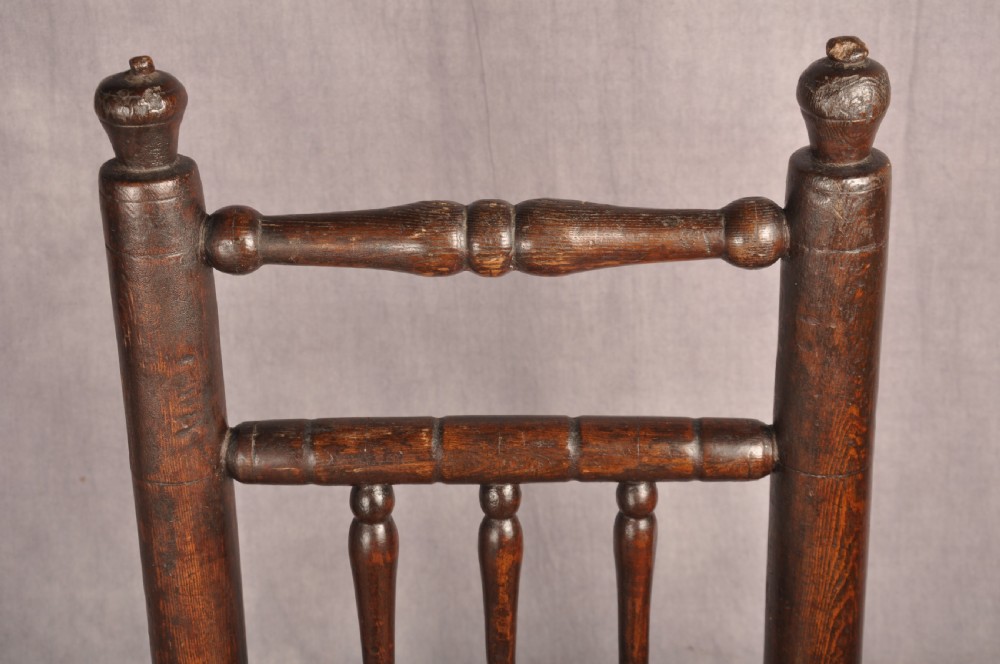 A near pair of dark 17th-century turned ash chairs with spindle backrests, turned stretchers, panel seats, and top finials. View XII