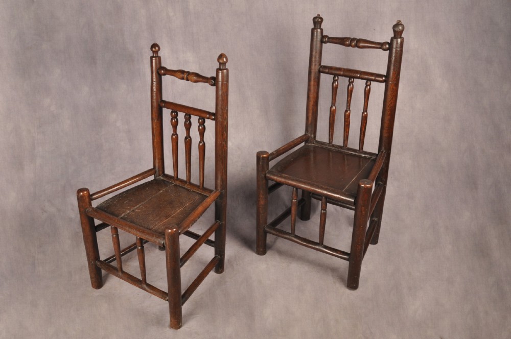 A near pair of dark 17th-century turned ash chairs with spindle backrests, turned stretchers, panel seats, and top finials. View XIV