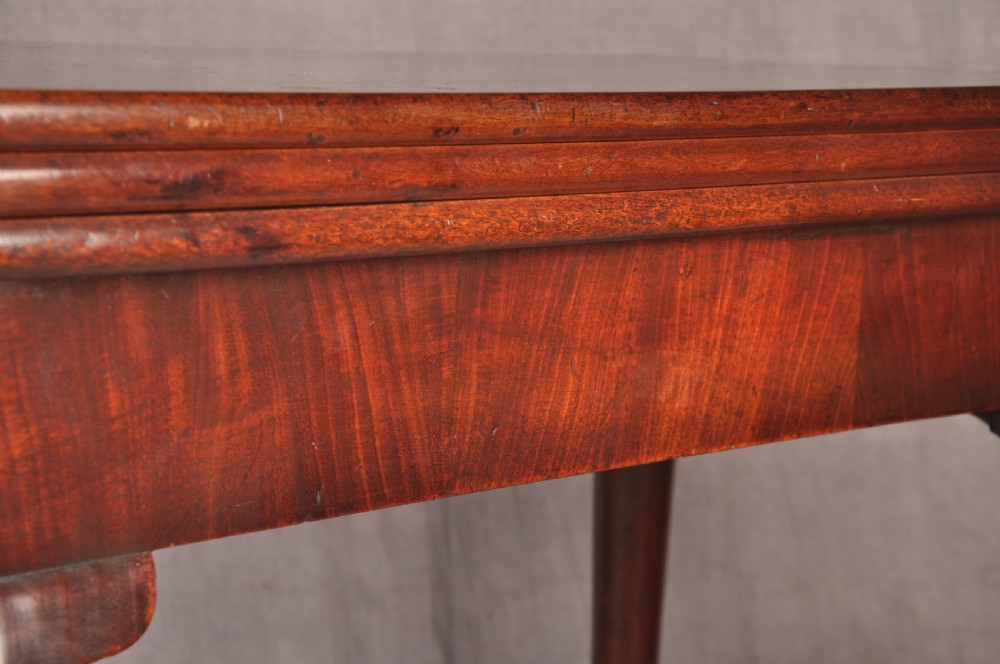 An 18th-century mahogany triple-top card table resting on four cabriole legs with pad feet. View III