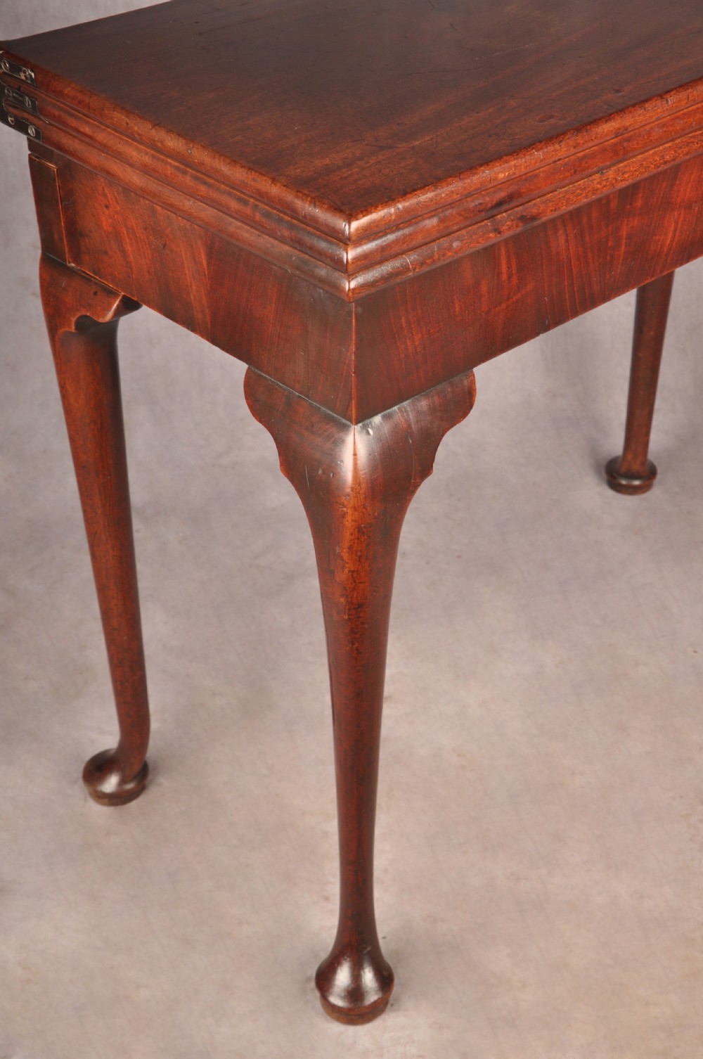 An 18th-century mahogany triple-top card table resting on four cabriole legs with pad feet. View IV