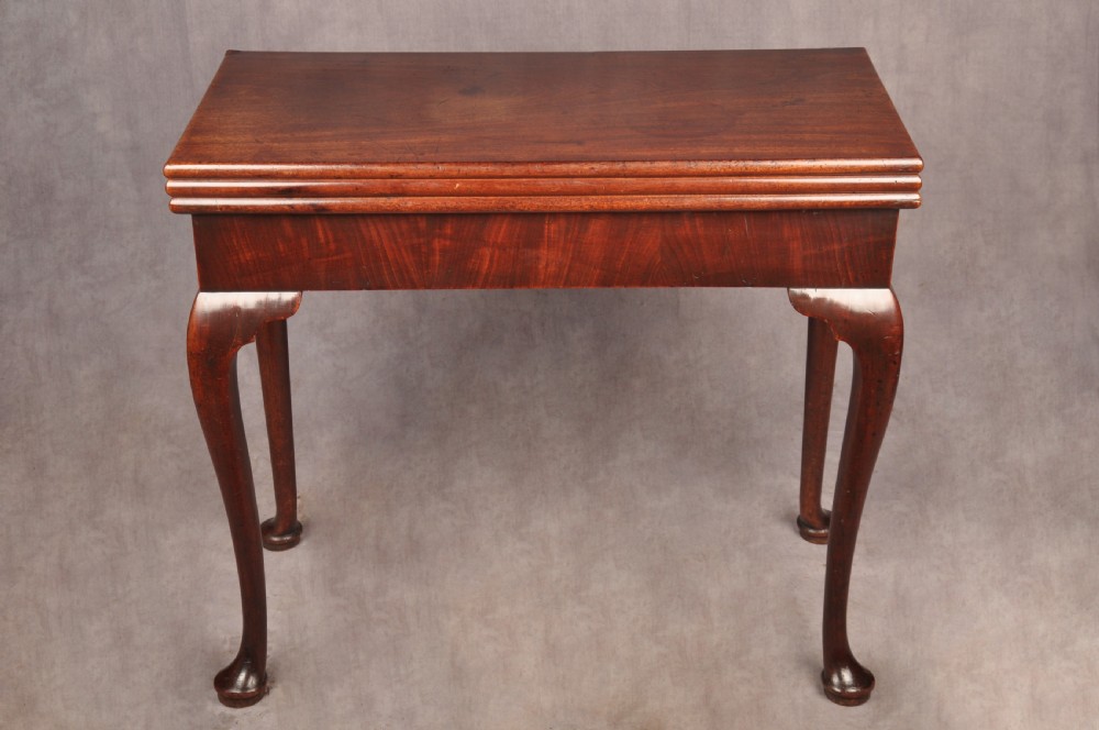 An 18th-century mahogany triple-top card table resting on four cabriole legs with pad feet. View VI